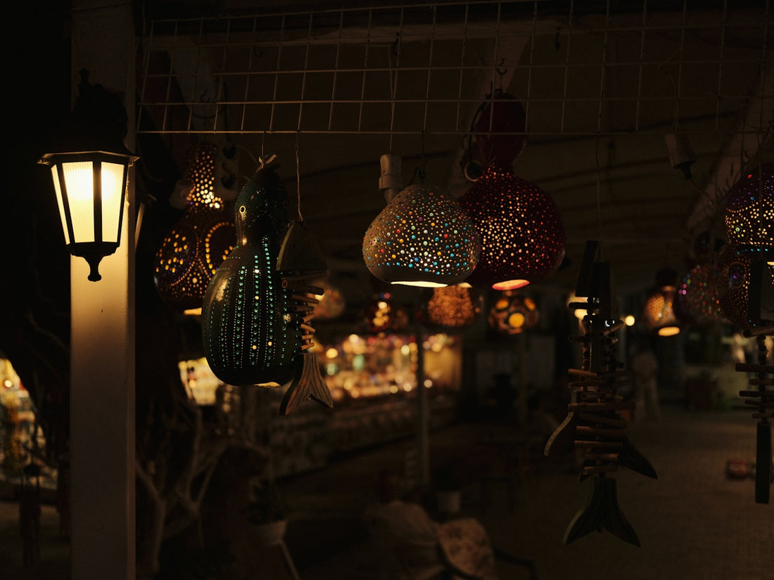 Decorative lamps hang in a dimly lit shop.