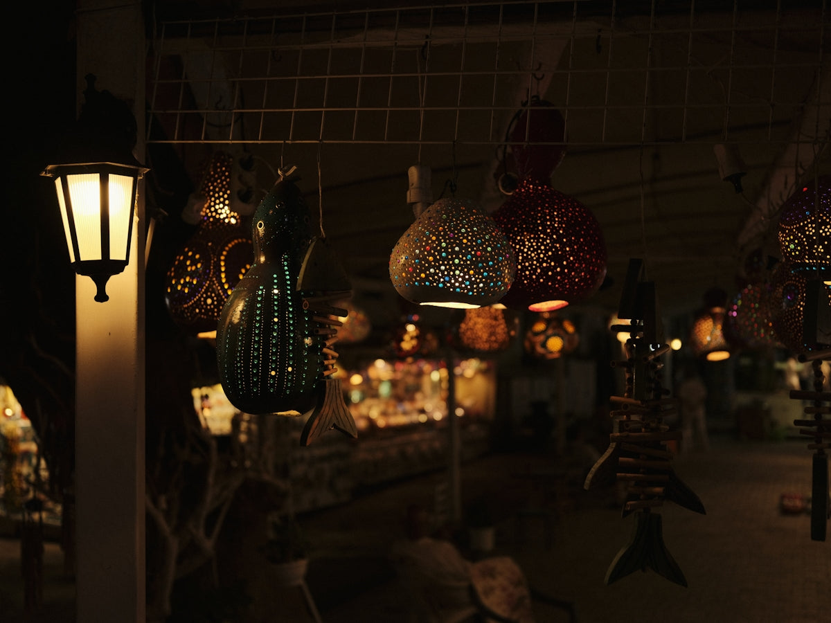 Decorative lamps hang in a dimly lit shop.